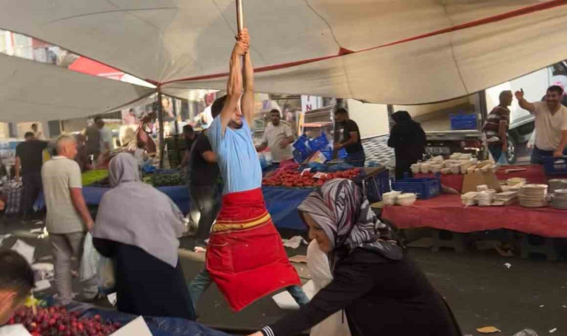 Kuvvetli rüzgarda pazarcı branda direğini bırakmadı, metrelerce havaya yükseldi